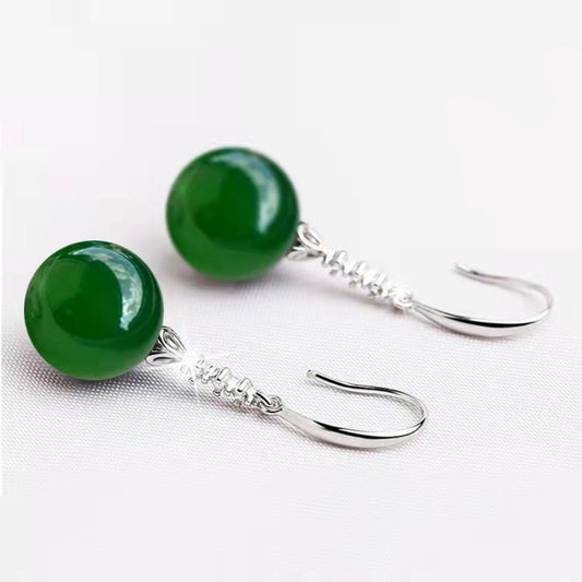 Green stone earrings with silver hooks on a white background