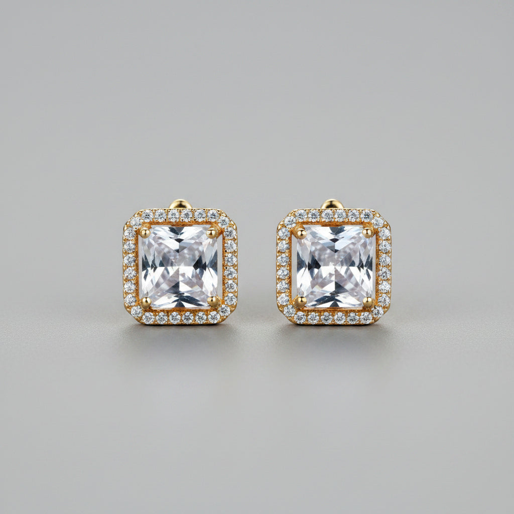 Gold square-cut gemstone earrings on a neutral background