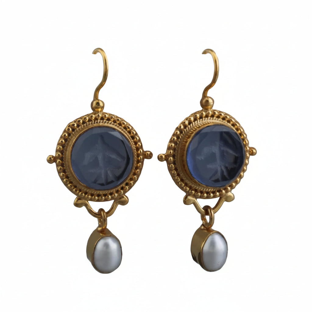 Pair of gold earrings with blue stones and pearl drops on a white background