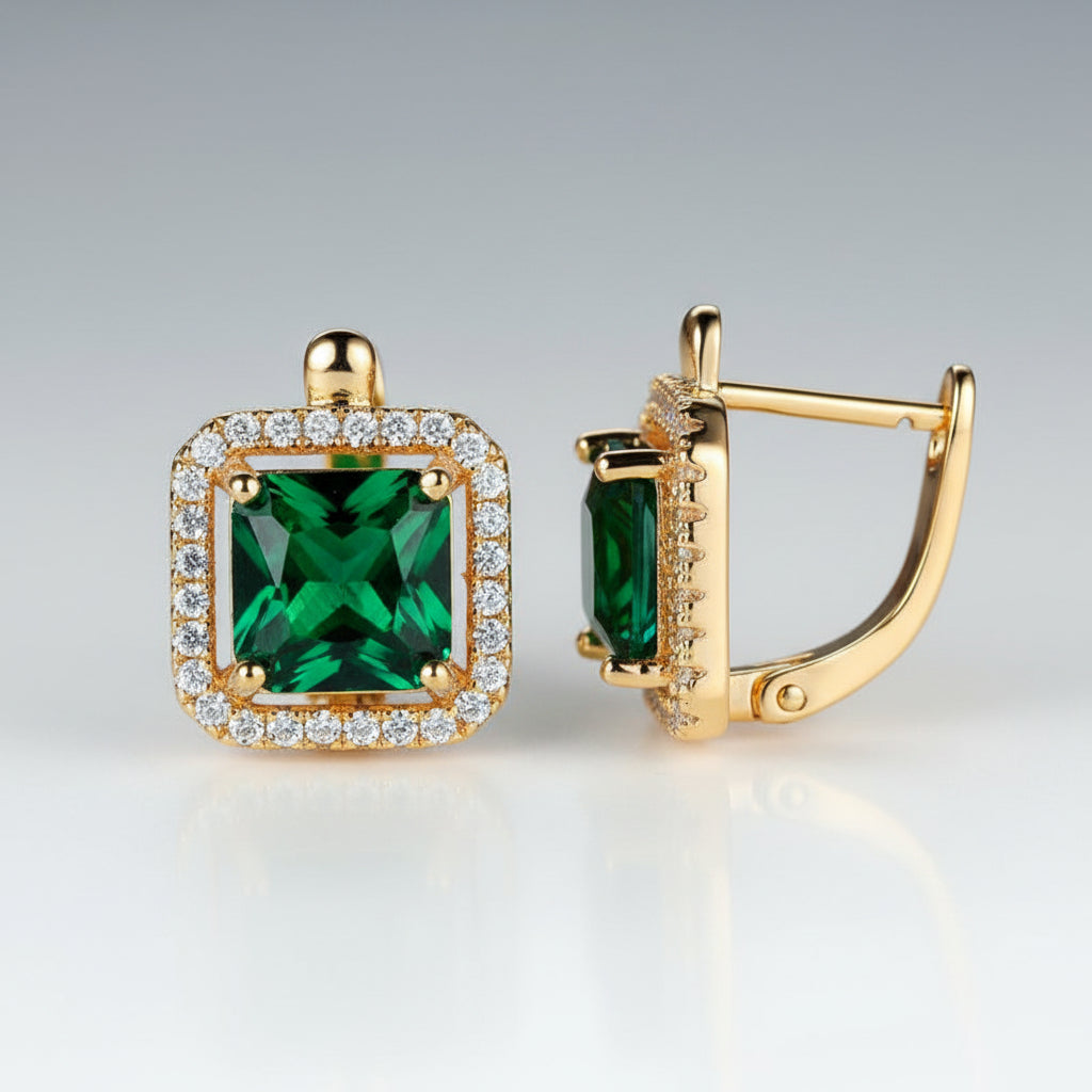 Gold earrings with green gemstones on a white background