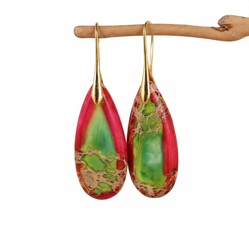 Teardrop-shaped earrings with gold hooks on a beige background