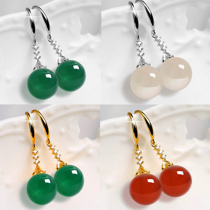 Four pairs of earrings with different colored gemstones on a white background