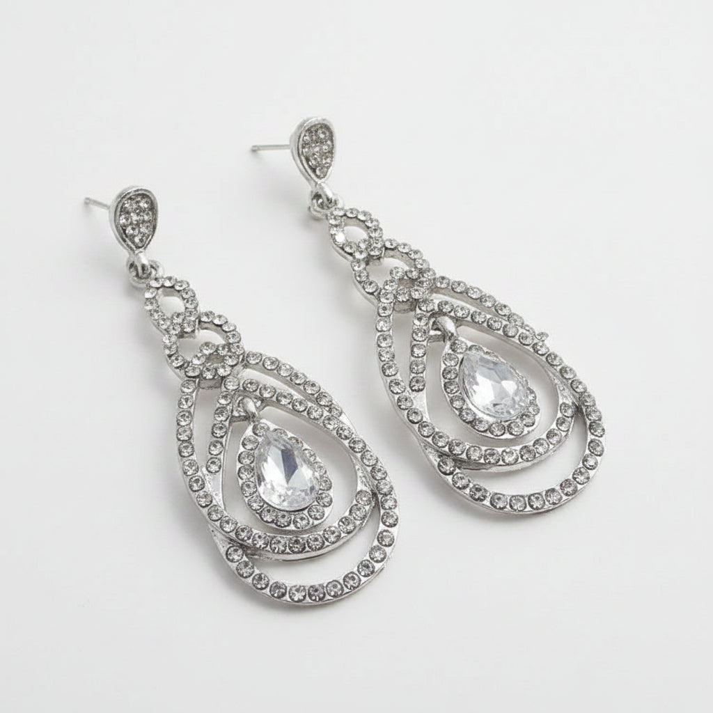 Silver teardrop earrings with clear stones on a white background