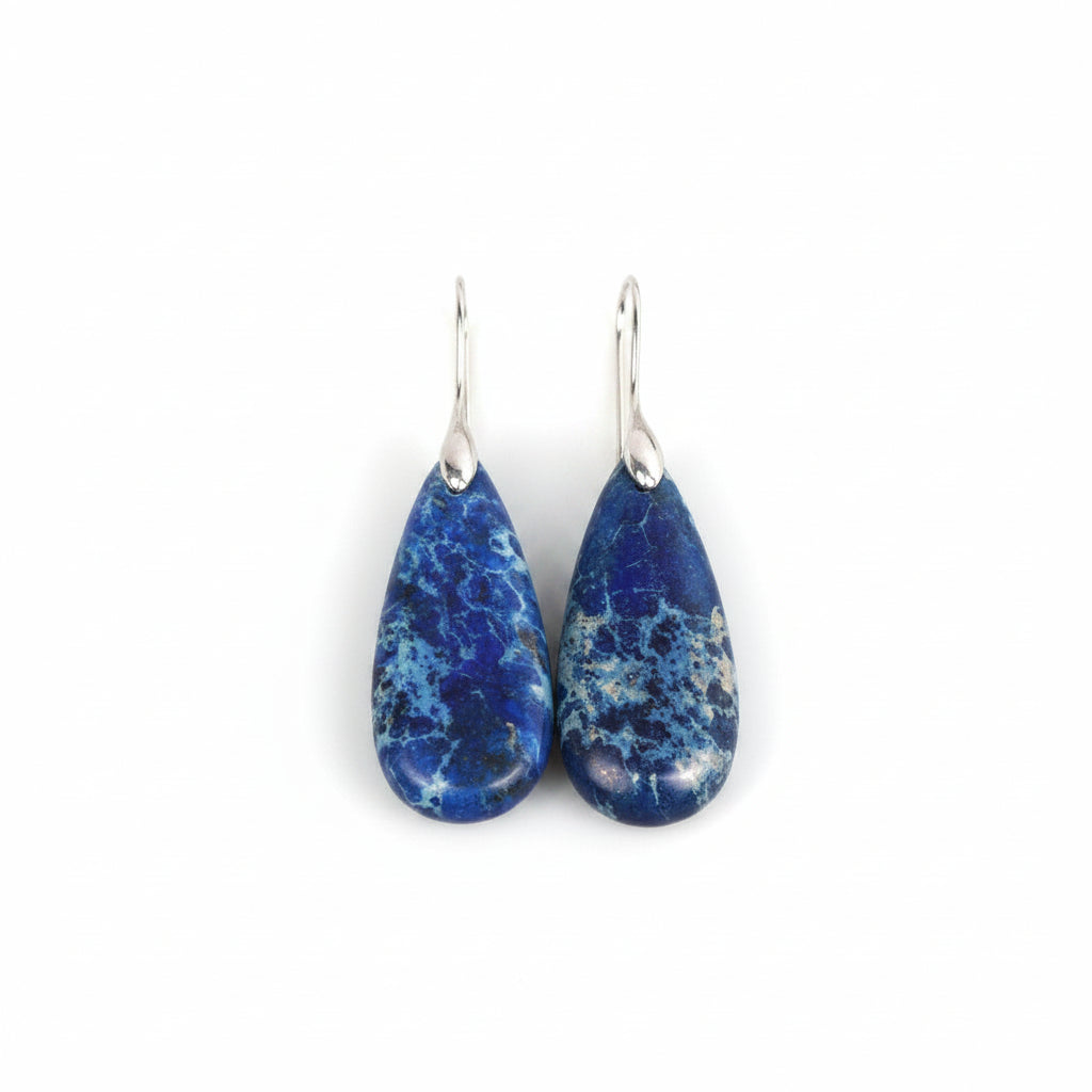 Blue teardrop earrings with silver hooks on a wooden surface