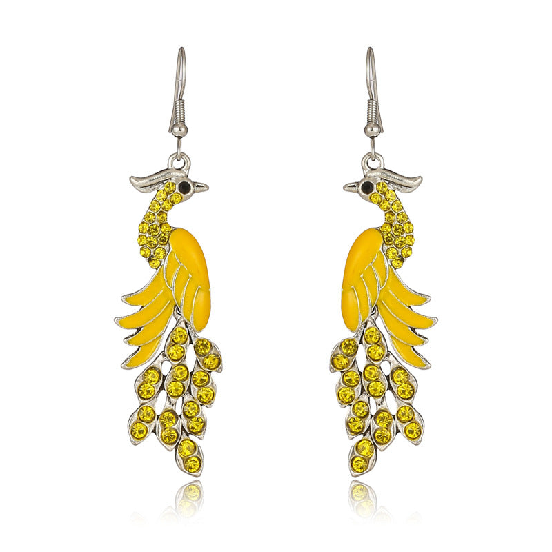 Pair of yellow feather-shaped earrings on a white background