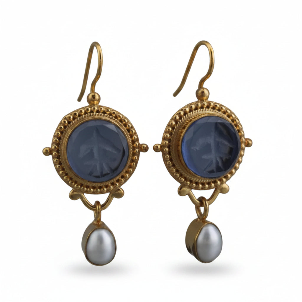 Gold earrings with blue stones and pearl drops on a white background