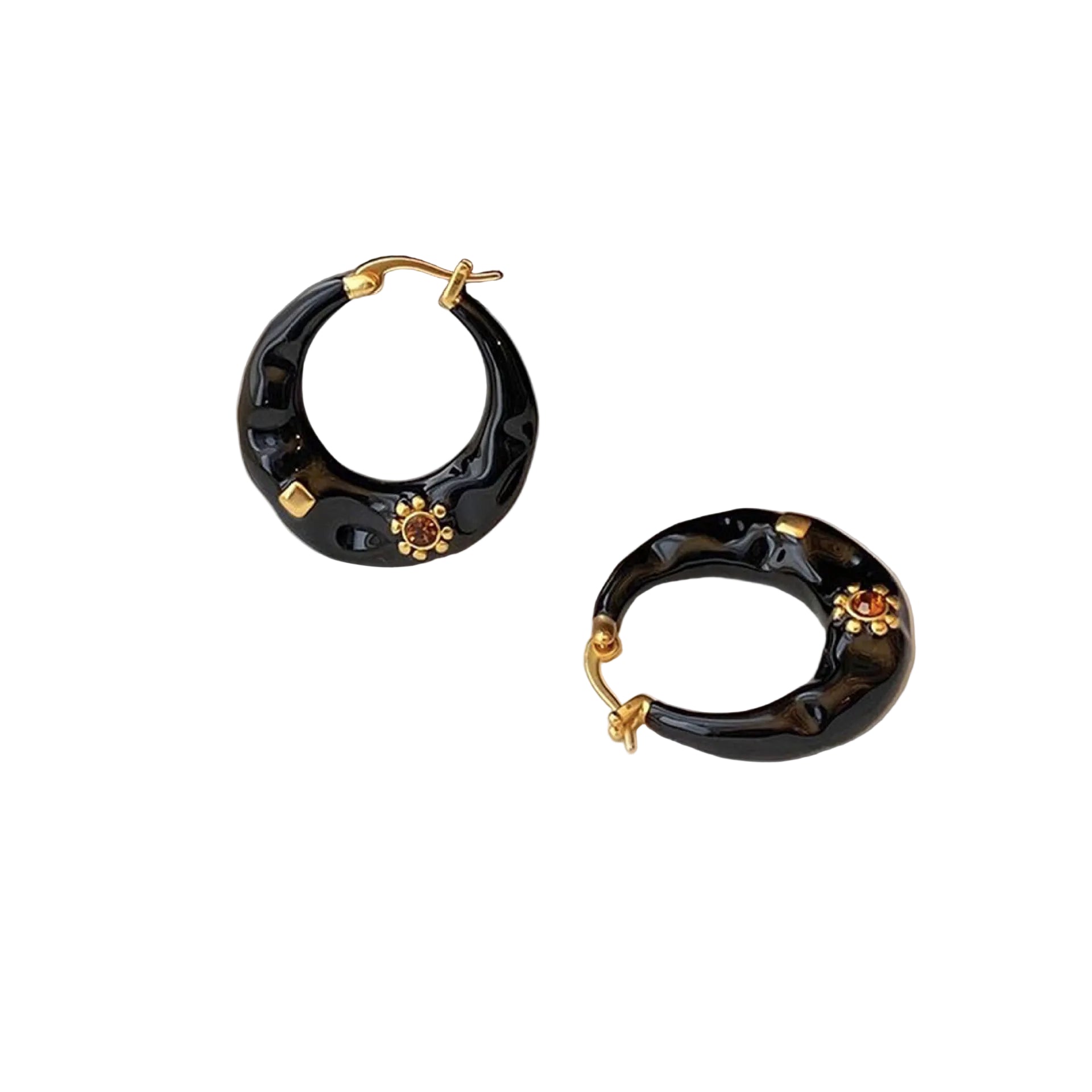 Black hoop earrings with gold accents on a light surface