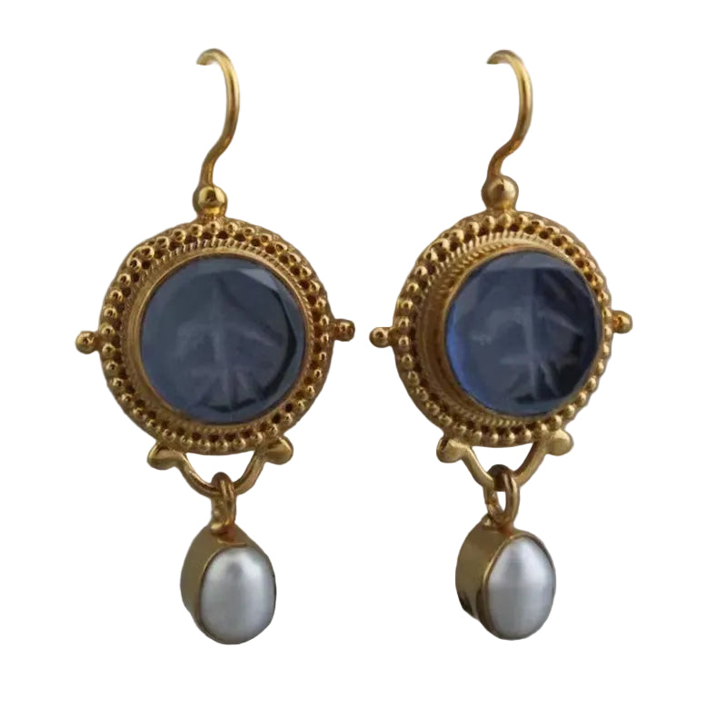 Gold earrings with blue stones and pearl drops on a white background