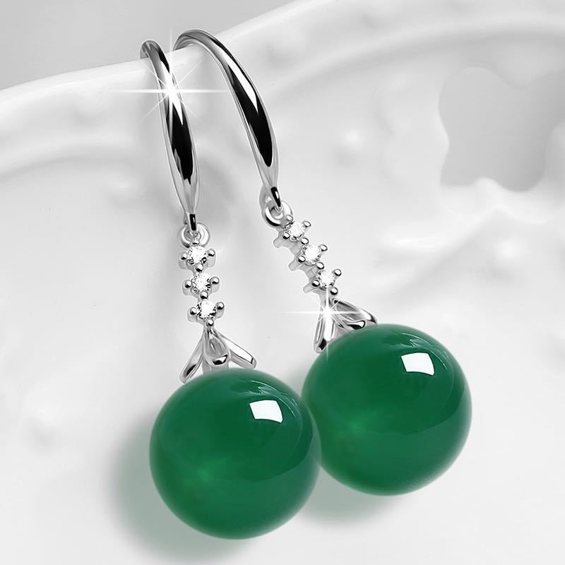 Green gemstone earrings with silver hooks on a white background