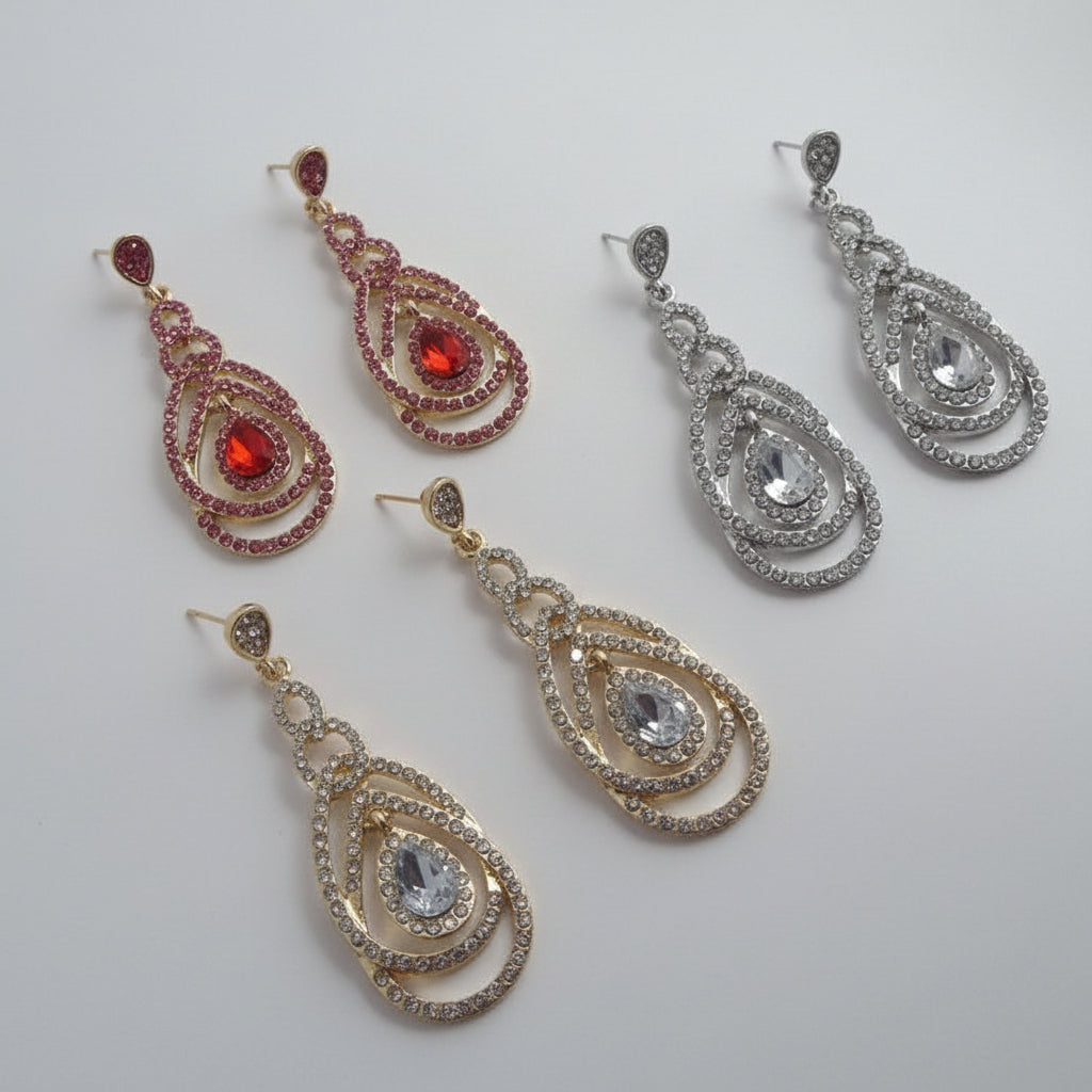 Three pairs of teardrop-shaped earrings in gold, silver, and red on a white background with text.