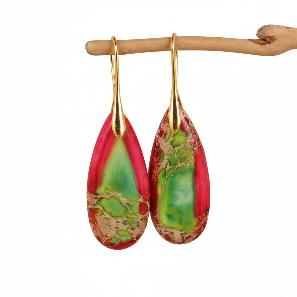 Teardrop-shaped earrings with gold hooks on a beige background